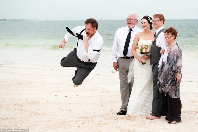 Một vị khách đang bay trong bức ảnh đám cưới chụp cô dâu – chú rể trên một bãi biển.