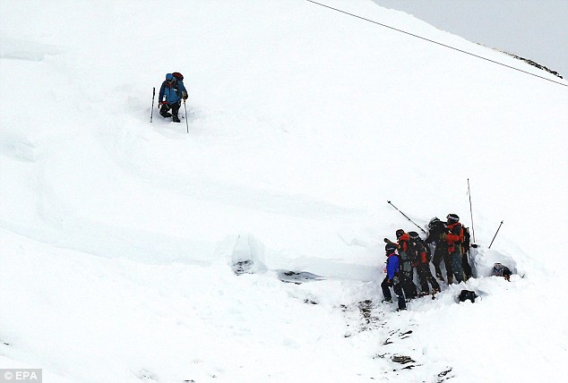 Một nhóm nhân viên cứu hộ tìm người mất tích sau trận tuyết lỡ hôm thứ tư.