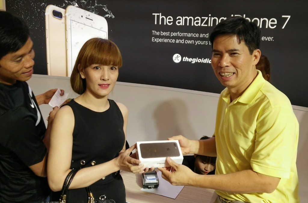Chủ tịch HĐQT Thế Giới Di Động Nguyễn Đức Tài trao iP7 cho khách hàng đầu tiên của đêm ra mắt.