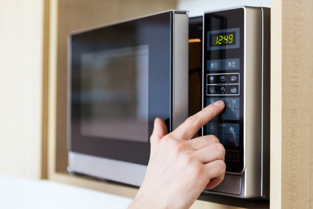 Detail of male hand while using the microwave