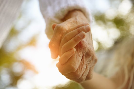 grandmother holding her grandchild's hand