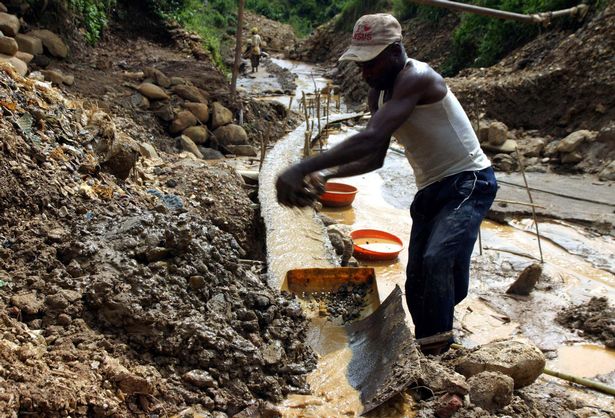 Một người đàn ông Congo đang rửa bùn và sàng trong một dòng sông nước chảy qua một mỏ vàng gần thị trấn miền đông Kamituga.