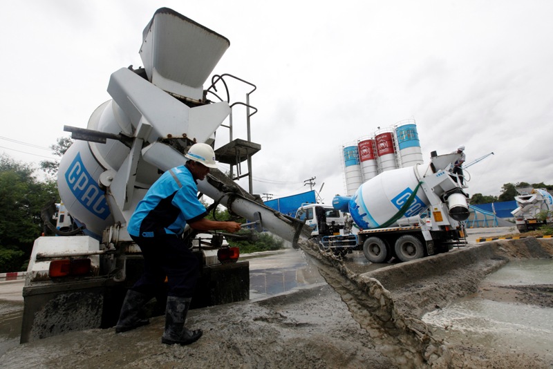 A worker cleans a cement truck at a ready mixed concrete plant of Siam Cement in Nonthaburi province, on the outskirts of Bangkok July 30, 2013. Siam Cement Pcl, Thailand's largest industrial conglomerate, is finally catching up with the capacity it overbuilt before the Asian financial crisis as it feeds demand from frontier markets including Myanmar and Cambodia. Picture taken July 30, 2013. REUTERS/Kerek Wongsa (THAILAND - Tags: BUSINESS) - RTX12599