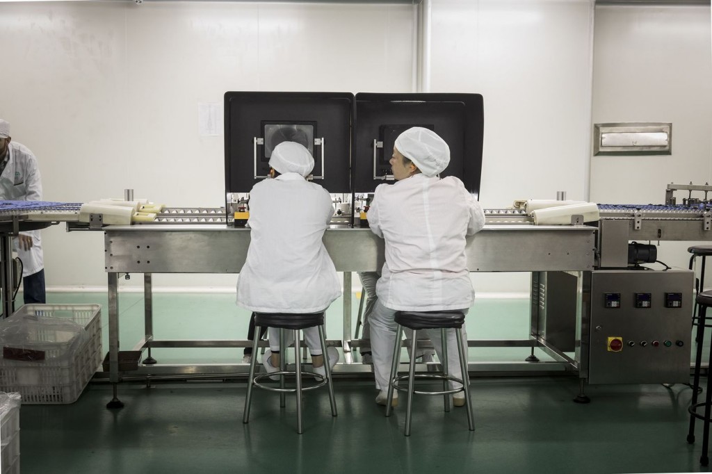 Nhân viên đang kiểm tra thuốc trên dây chuyền sản xuất của Nhà máy Dược phẩm Quảng Châu