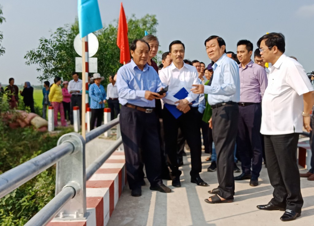 Cựu Chủ tịch Nước Trương Tấn Sang nol1i chuyện với lãnh đạo tỉnh Long An trên cây cầu vừa được xây dựng. ảnh: Song Minh