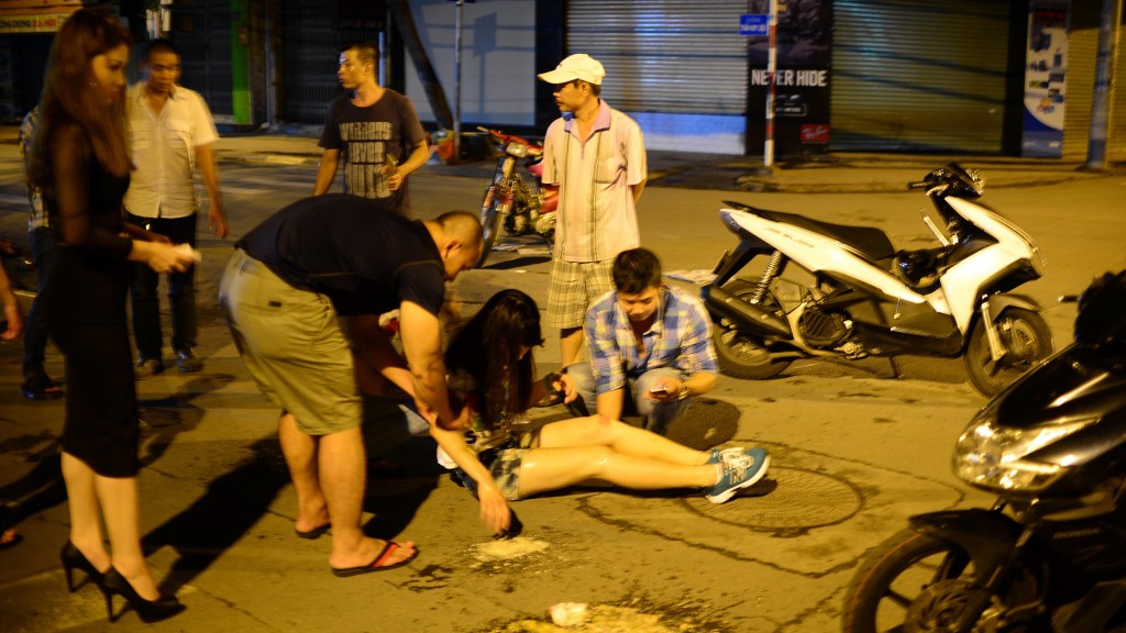 Một cô gái bị tai nạn giao thông do uống rượu bia được người đi đường cứu giúp .Ảnh T.T.D.